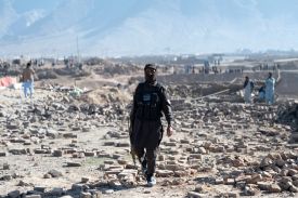 A Taliban security officer walks past rubble at the site of a Pakistani airstrike on the outskirts of Kabul on March 13.