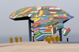 A man reads his newspaper in front a map of Africa at the Place du Souvenir Africain, in Dakar, on January 27, 2016.