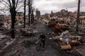 A man pushes his bike through debris in Bucha, Ukraine, on April 6, 2022.