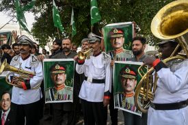 Awami Rickshaw Union workers hold posters of Pakistan Army chief Asim Munir in Lahore, Pakistan, on April 8, after the United States and Iran agreed to a two-week cease-fire.