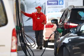 A worker fills cars up with gasoline at a service station in Santiago, Chile.