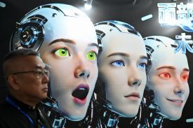 A man stands next to a poster showing humanoid robots at the International AI Application and Robotics Innovation Exhibition in Beijing on March 18.
