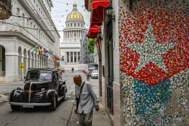 A man walks on a street in Havana.