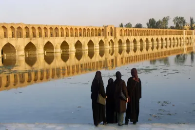 Iranian women watch the Si-o-Se Pol bridge on the Zayandeh River in Isfahan, Iran, on July 13, 2002.