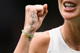 A tattoo reading "Carpe Diem" and a bracelet with the colors of the Ukrainian flag are pictured on the hand of Ukraine's Elina Svitolina.