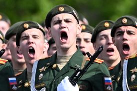 Men in military uniforms are shown close-up and appear to be shouting.