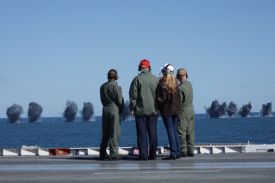 President Donald Trump and First Lady Melania Trump observe naval flight demonstrations on the deck of the USS George H.W. Bush aircraft carrier on October 5, 2025 off the eastern coast of the United States.