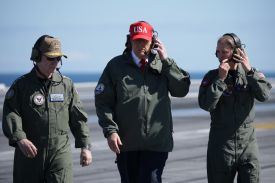 President Donald Trump observes naval flight demonstrations on the deck of the USS George H.W. Bush aircraft carrier on October 5, 2025 off the eastern coast of the United States.