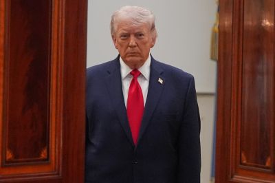 Trump stands at the opening of a doorway.