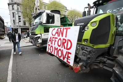 Members of the public make their way past trucks and tractors as fuel protesters block O’Connell Street in Dublin on April 11.