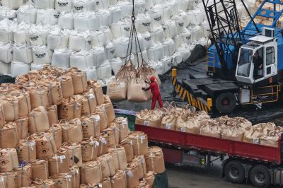 A worker loads sulfur at a storage yard on a wharf in Nanjing, China.