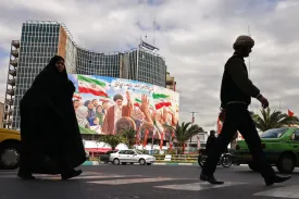 Commuters pass a billboard of slain Iranian Supreme Leader Ali Khamenei at Valiasr Square in Tehran on April 19.