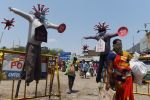 A women wearing a facemask walks past Covid-19 awareness scarecrows placed by Chennai municipality at a market during a government-imposed nationwide lockdown as a preventive measure against the COVID-19 coronavirus, in Chennai on April 11, 2020.