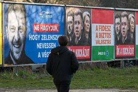 A pedestrian walks past billboards featuring Ukrainian President Volodymyr Zelensky, reading “Don’t let Zelensky have the last laugh,” and another billboard featuring Zelensky (left), Hungarian opposition leader Peter Magyar, and European Commission President Ursula von der Leyen, in Budapest.