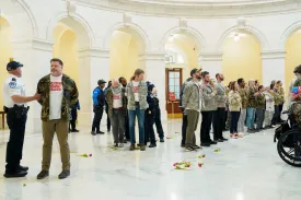 Veterans, military family members, and supporters are detained by U.S. Capitol Police officers during an demonstration in the Cannon House Office Building on Capitol Hill, Washington, on April 20.
