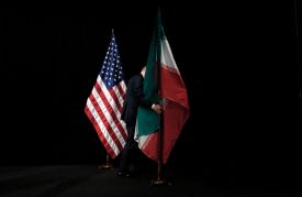 A staff member removes the Iranian flag from the stage during Iran nuclear talks in Vienna on July 14, 2015.