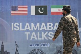 A Pakistani Ranger walks past a billboard for the U.S.-Iran peace talks in Islamabad on April 12.