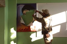 A rebel fighter rips a portrait of slain Hezbollah leader Hassan Nasrallah in the town of in Qusayr in Syria's central Homs province on December 15, 2024.
