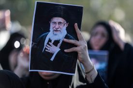 A woman holds up an image of Iran's supreme leader, Ayatollah Ali Khamenei, during a symbolic funeral in Baghdad on March 1.