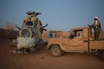 An Azawad Liberation Front militant stands on a pickup truck next to a damaged Russian Mi-24 helicopter at the former Africa Corps barracks in Kidal, Mali, on May 6.
