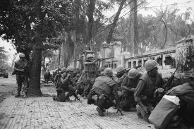 U.S. Marines hide behind a wall in Hue, South Vietnam in February 1968.
