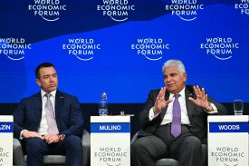 Ecuadoran President Daniel Noboa and Panamanian President Jose Raul Mulino sit during a panel at the World Economic Forum annual meeting in Davos, Switzerland. Behind them is a blue background with World Economic Forum logos.