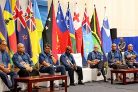 Flanked by their national flags, the leaders of Pacific Islands nations sit together during the Pacific Islands Forum.