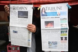 A vendor displays morning newspapers at his roadside stall in Islamabad on April 8.