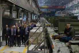 Men in suits visit a Russian tank factory.