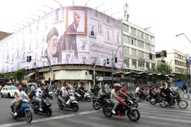 Iranians drive past a billboard featuring late Iranian Supreme Leader Ali Khamenei, killed during the U.S.-Israeli attack on Iran, on a street in Tehran on May 5.