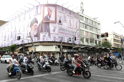 Iranians drive past a billboard featuring late Iranian Supreme Leader Ali Khamenei, killed during the U.S.-Israeli attack on Iran, on a street in Tehran on May 5.