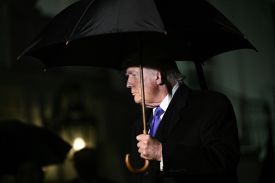 Donald Trump holds an umbrella.