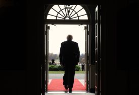 Trump is shown from behind as he walks out a door.