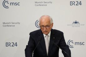 Wolfgang Ischinger dressed in a dark suit speaks at a lectern in front of a backdrop that features the logos of the Munich Security Conference, the Bayerischer Hof Hotel, and the BR24 news program.