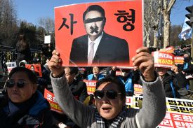 A protester holds a sign of former South Korean President Yoon Suk-yeol
